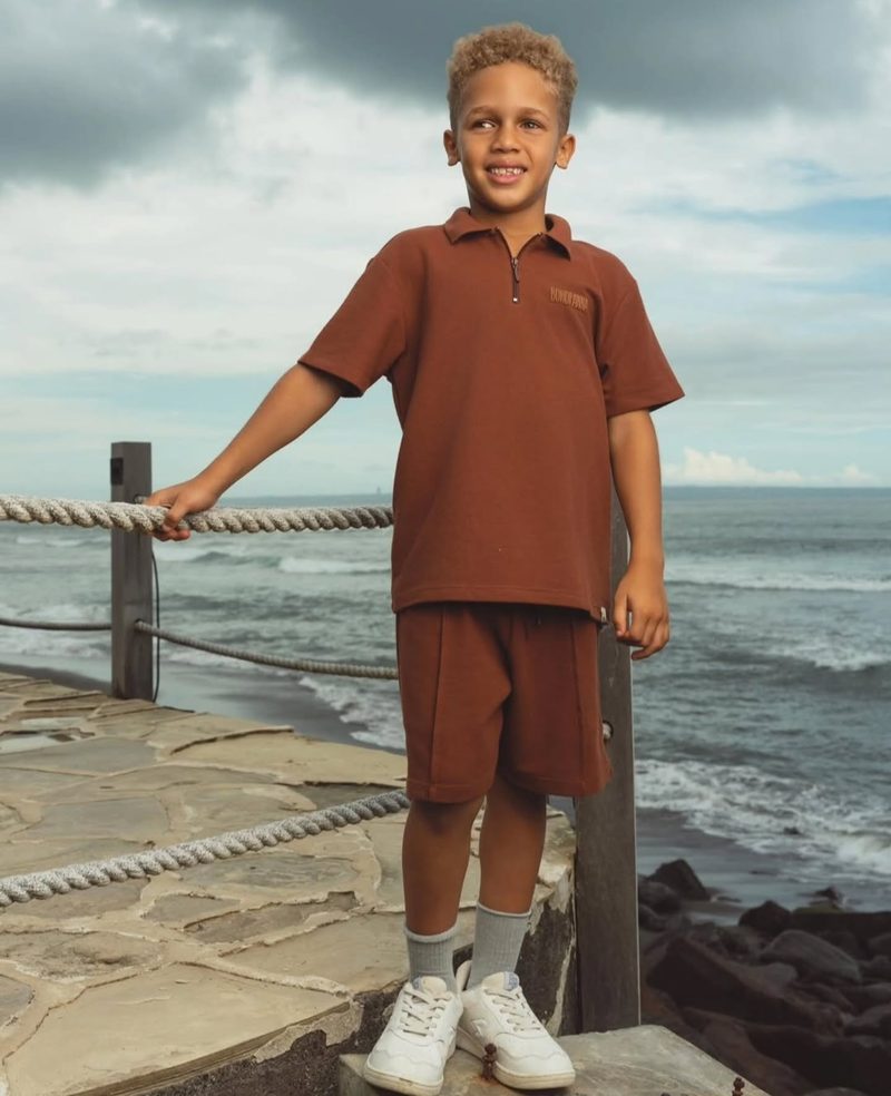 Keanu Tetteh in a brown co-ord outfit at a sea railing