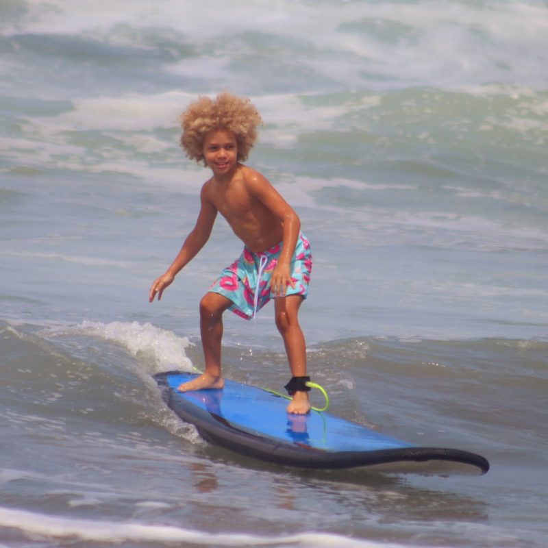 Keanu Tetteh riding a wave, child surfer in Bali