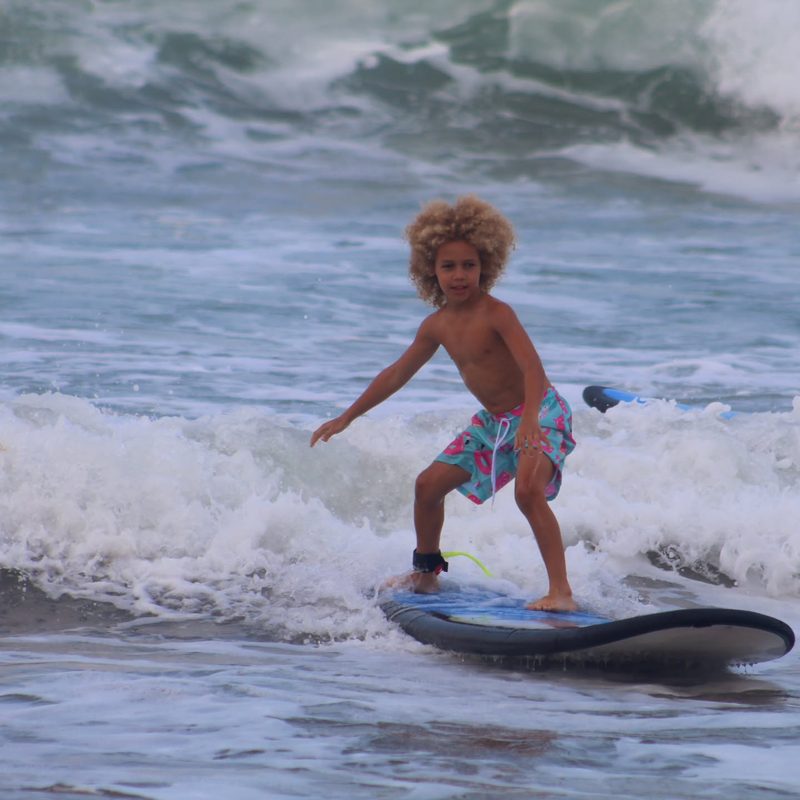 Keanu Tetteh surfing a wave on a blue surfboard in Bali